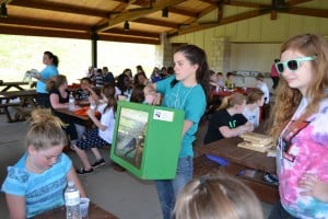California University of Pennsylvania student chapter president Becca Robich and another student, Sarah Martin, show fifth graders a display box created by the Pennsylvania Game Commission to teach them about bluebirds and reasons for their decline. Image Credit: Kannsas Michaels