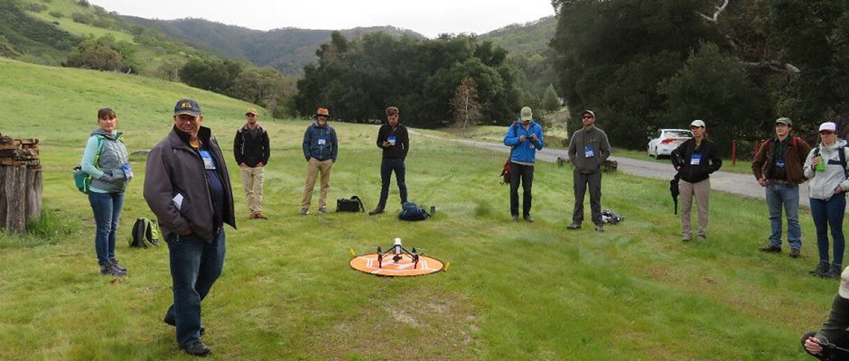 A group of wildlife management professionals preparing to launch a conservation drone in the field 