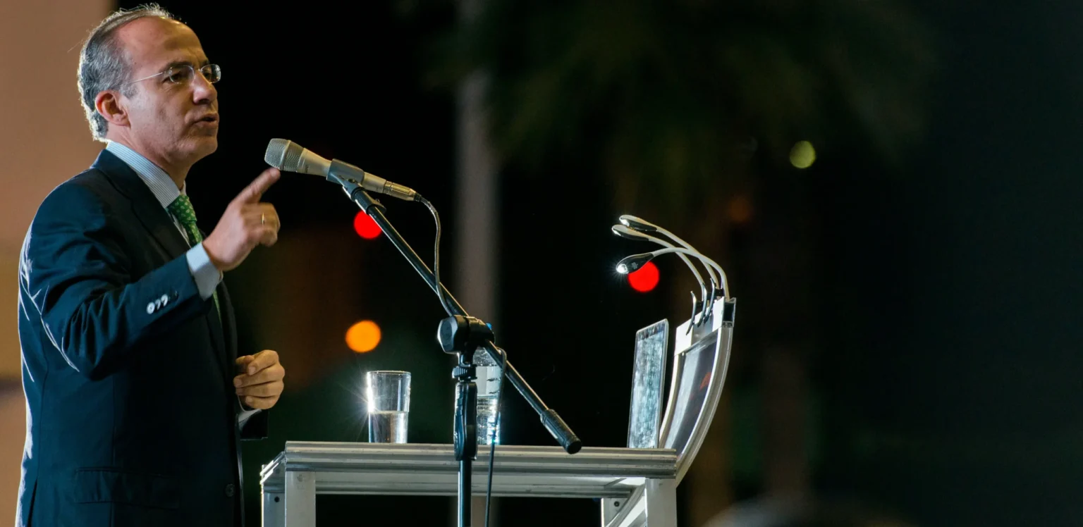 Speaker presenting at a podium during a public event, representing the use of science and research in wildlife conservation decision-making.