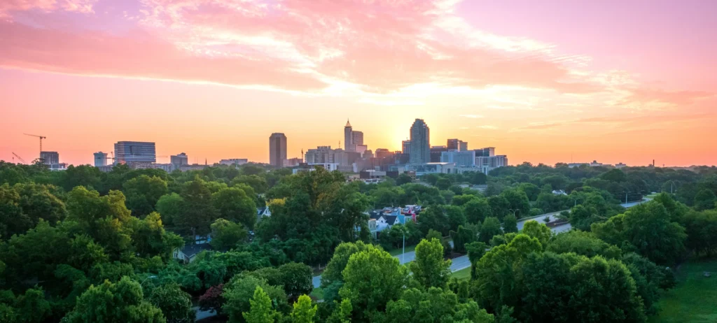 City skyline at sunset showing urban expansion, green spaces, and infrastructure representing economic growth and sustainable development.