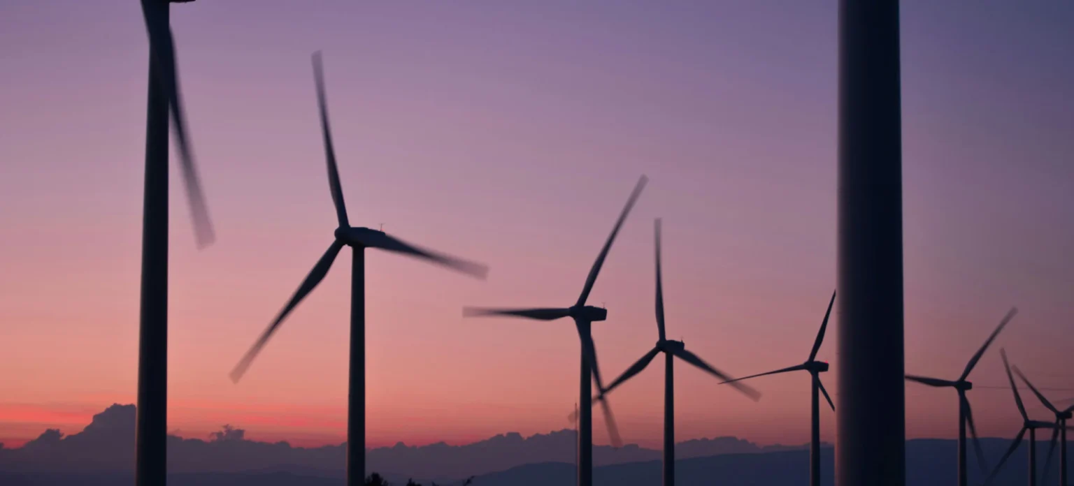 Wind turbines generating clean renewable energy at sunset, representing sustainable energy development and climate-friendly power production.