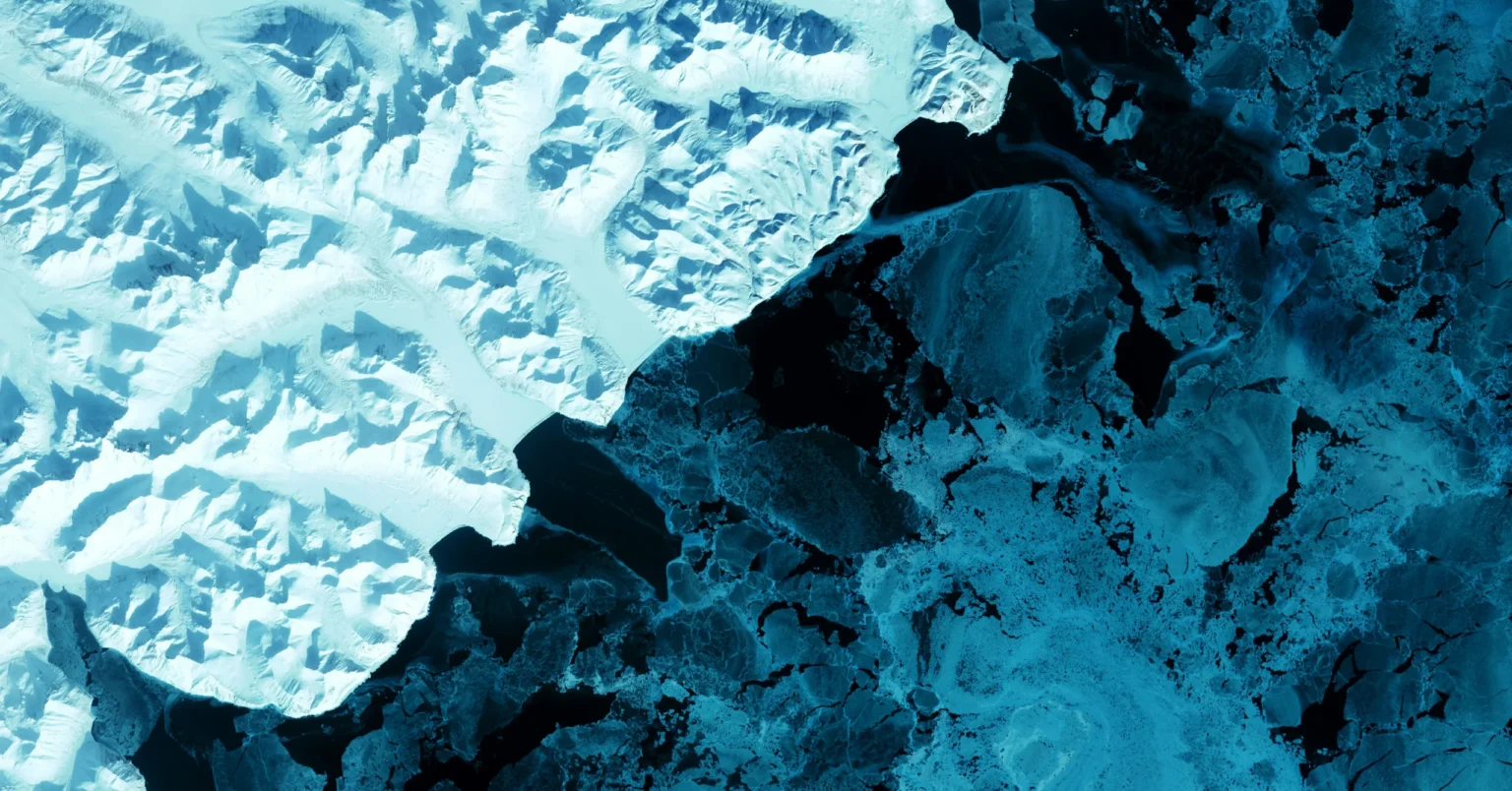 Aerial view of melting glacier ice meeting dark ocean water in the Arctic, showing the effects of climate change on polar ecosystems.