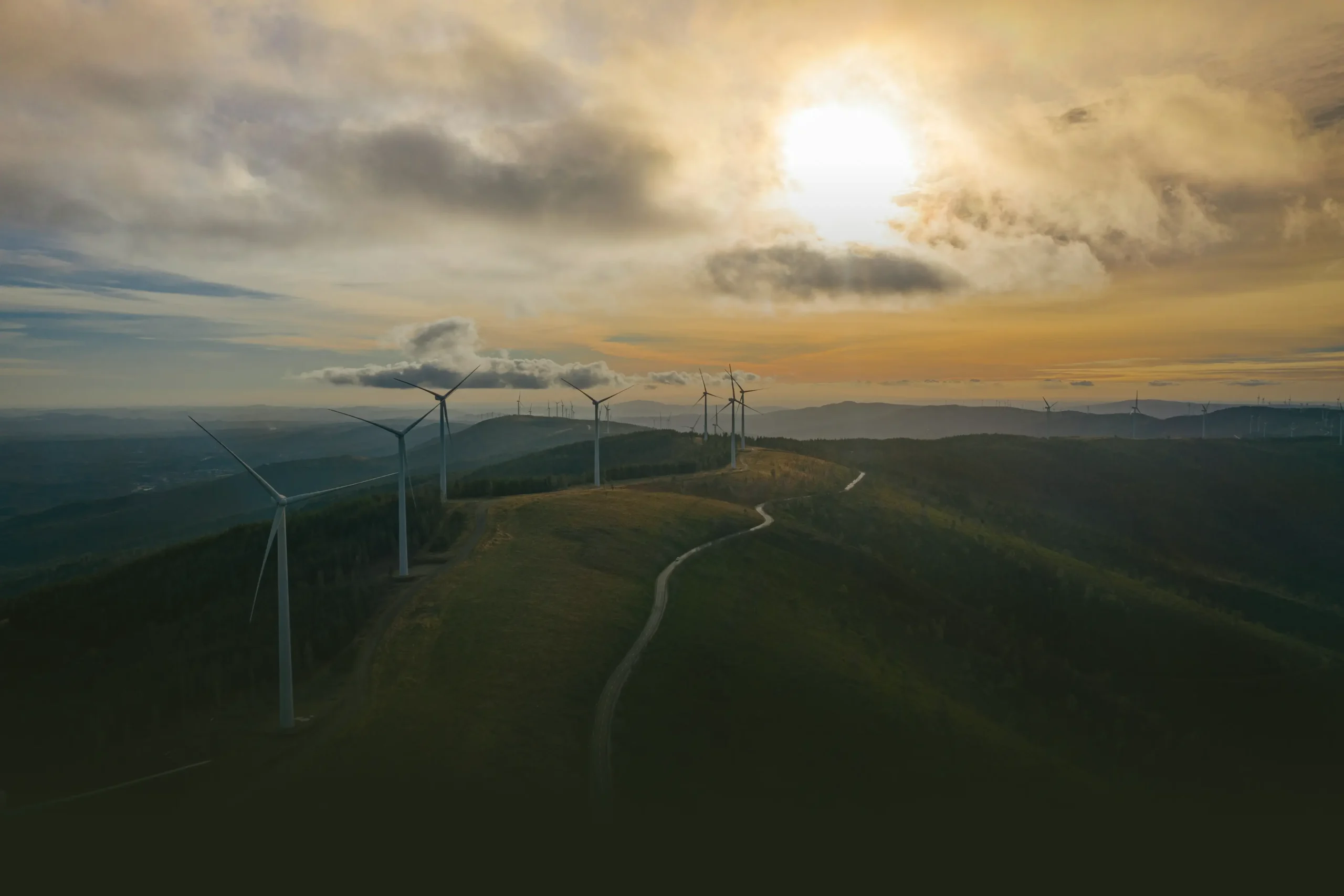 Wind turbines installed along a mountain ridge, illustrating large-scale wind energy development and its interaction with natural landscapes.