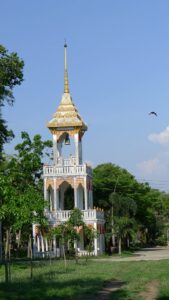 A flying fox passes by a clock tower near Thailand’s Wat Luang temple.
