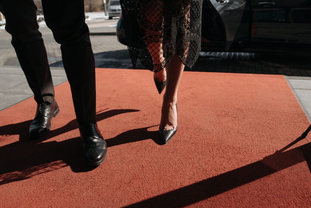 image of two individuals walking on a red carpet